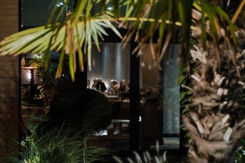 a group of people sitting at a table in a restaurant at Hôtel & Restaurant La maison des blés in Boutervilliers