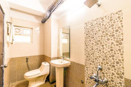 a bathroom with a toilet and a sink and a shower at Octave Kings Suites in Bangalore