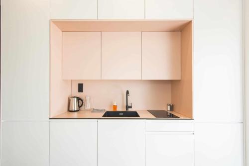a kitchen with white cabinets and a sink at Demänová Rezort in Liptovský Mikuláš
