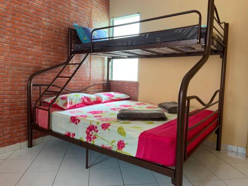 a bedroom with two bunk beds in a brick wall at Pangkor Damai in Pangkor