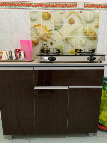 a kitchen with a stove and a counter top at Pangkor Damai in Pangkor