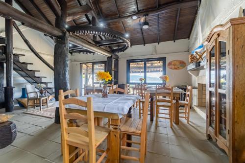 uma sala de jantar com uma mesa longa e cadeiras em Pousada Caminho do Mar em Bombinhas