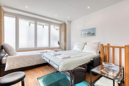 Habitación pequeña con cama y ventana en Les Vignes de Montmartre en París