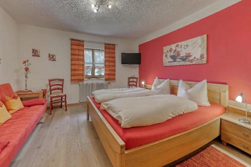 a bedroom with two beds and a red wall at Wofahanslhof in Eschlkam