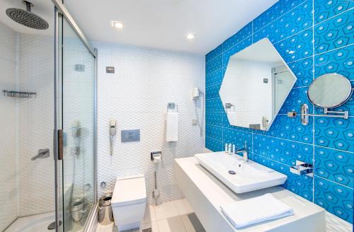 a bathroom with a sink and a glass shower at The Elysium Styles Taksim in Istanbul