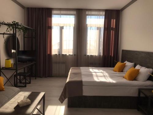 a bedroom with a bed and a desk and windows at Popock Goris in Goris