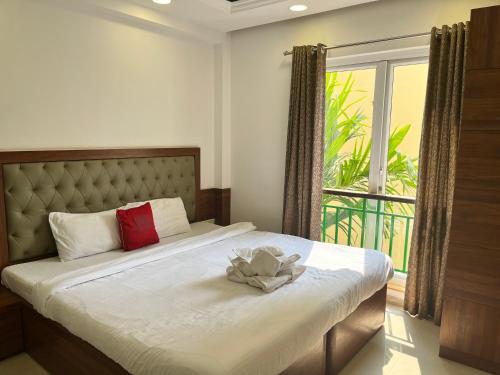 a bedroom with a bed with a flower on it at Areia De Goa, Comfort Stay Apartment near Baga Beach in Baga