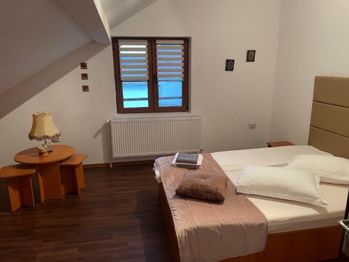 a bedroom with a large bed and a window at Pensiunea Marmis in Rîu Bărbat