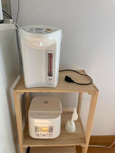 a white appliance sitting on a wooden shelf at 薬水君近江八幡水郷民泊貸し切り in Omihachiman