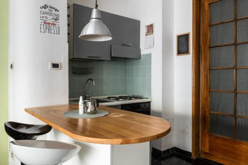 a kitchen with a wooden counter and a sink at Boldrini apartment with balcony by Wonderful Italy in Bologna