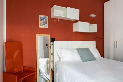 a bedroom with a white bed and a red wall at Boldrini apartment with balcony by Wonderful Italy in Bologna