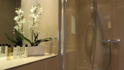 劍橋的住宿－維耶城市之家酒店，架子上植物的淋浴浴室