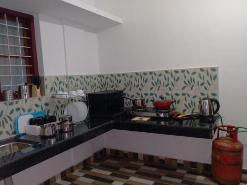 a kitchen with a stove and a counter top at Bethel Service Villa, Mananthavady, Wayanad in Wayanad