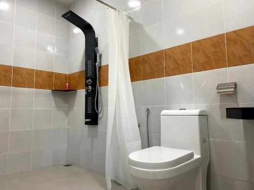 a bathroom with a toilet and a shower curtain at Tokman Inn in Pantai Cenang
