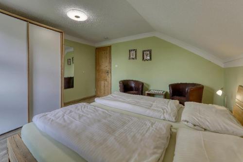 a bedroom with two beds and two chairs at Wofahanslhof in Eschlkam