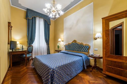 a bedroom with a blue bed and a chandelier at Locanda Sant'Agostin in Venice