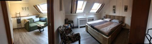 a bedroom with a bed and a couch and windows at Hotel Pieter de Coninck in Westkapelle