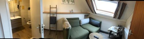 a living room with a green couch and a window at Hotel Pieter de Coninck in Westkapelle