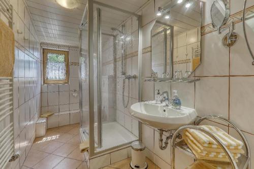 a white bathroom with a shower and a sink at Wofahanslhof in Eschlkam