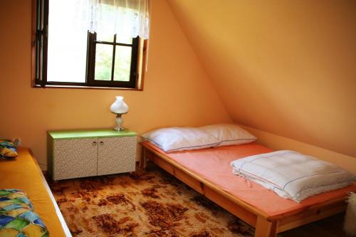 1 dormitorio con 2 camas y ventana en Summer House Stare Jabłonki, en Stare Jabłonki