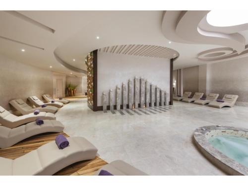 a large room with a swimming pool and chairs at Kaya Palazzo Resort & Casino in Kérynia