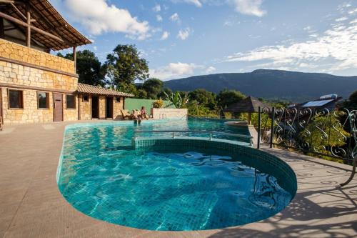 a large swimming pool with blue water at Lendas do Capão Pousada in Vale do Capao