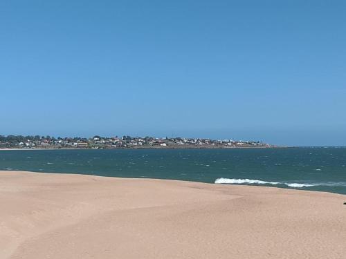 a beach with the ocean and buildings in the background at BAHIA SAN FRANCISCO, casa Gaviotas, a 80 metros del mar, Uruguay in Piriápolis