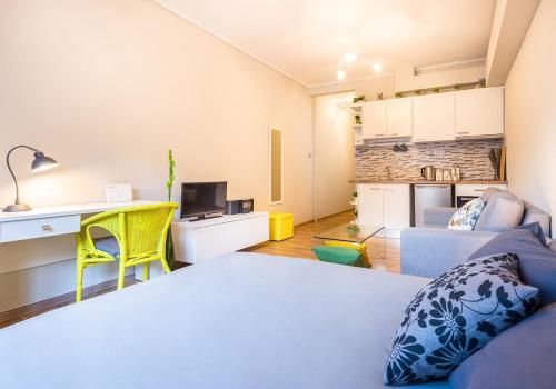 Una sala de estar con una cama y una cocina. en Unlock Athens from sunny studio near Acropolis, en Atenas