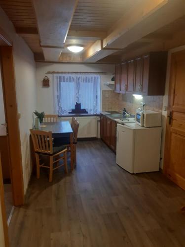 a small kitchen with a table and a refrigerator at Apartmány Roudnice in Jestrabi V Krkonosich
