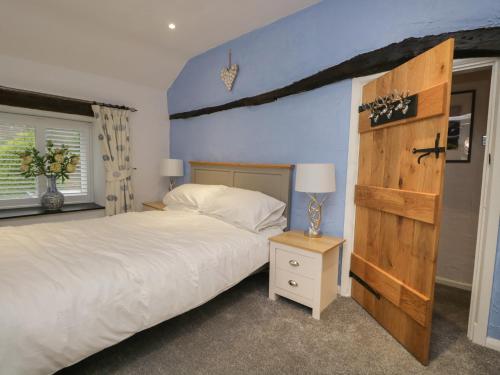 a bedroom with a large bed and a wooden headboard at Green Stile Cottage in Windermere