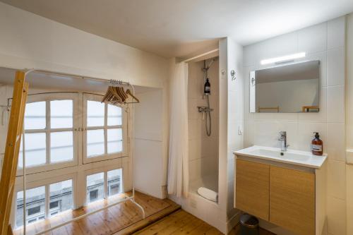 une salle de bain avec un lavabo, un miroir et une fenêtre dans l'établissement Le Parvis-Beau Duplex centre, à Rennes