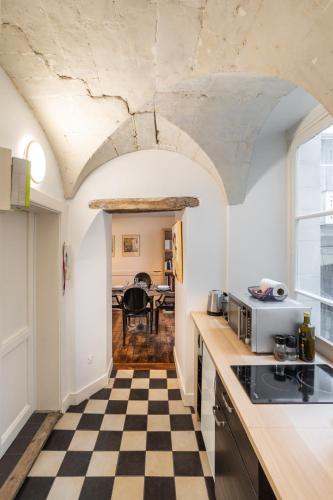 - une cuisine avec un sol en damier noir et blanc dans l'établissement Le Parvis-Beau Duplex centre, à Rennes