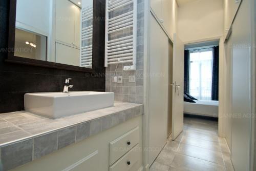 une salle de bain avec un lavabo blanc et un miroir dans l'établissement Colombe, à Cannes