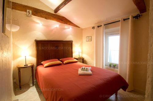 une chambre avec un lit rouge avec deux oreillers dans l'établissement Maillot, à Cannes