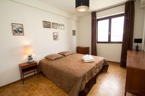 une chambre avec un grand lit et une fenêtre dans l'établissement Velapop, à Cannes