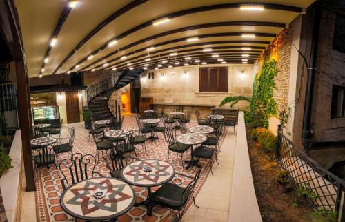 een restaurant met tafels en stoelen en een trap bij Sam Franss Boutique Otel in Hatay