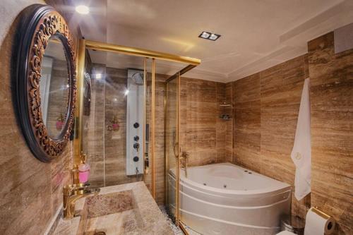 uma casa de banho com uma banheira e um chuveiro e uma banheira em Sam Franss Boutique Otel em Hatay