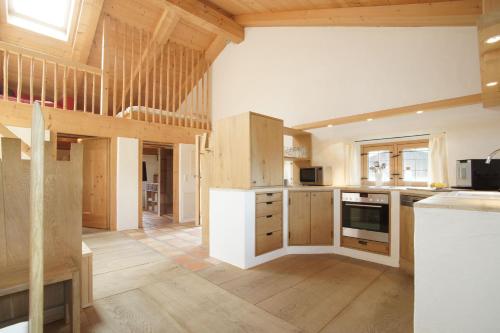 a large kitchen with wooden cabinets and a staircase at Ansitz Parstorfer in Chieming