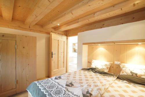a bedroom with a large bed with a wooden ceiling at Ansitz Parstorfer in Chieming