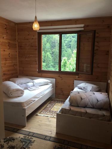 two beds in a room with a window at AYDER ŞAFAK Apart in Ayder Yaylasi