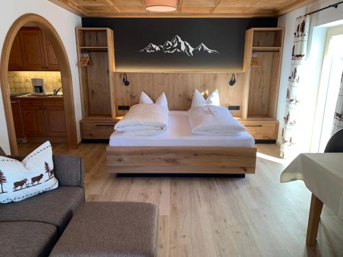 a bedroom with a bed and a couch in a room at Ferienwohnungen Hörmann in Hirschegg