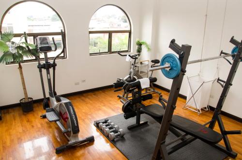 a gym with two treadmills and two windows at Hotel Plaza Real Suites & Apartments San Jose in San José
