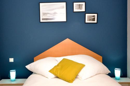 a bed with a yellow pillow on a blue wall at La Casa de las Aldeas in Daroca