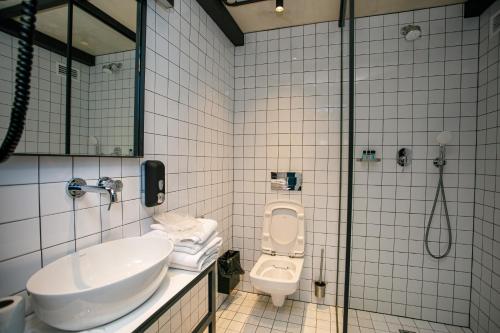 a bathroom with a sink and a toilet and a shower at Campus Community A-Rooms in Kyiv