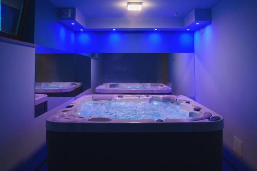 a hot tub in a bathroom with blue lights at TatrApart in Zakopane