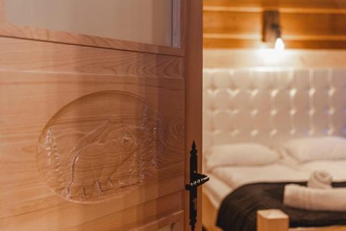 a door with a carving of a bed in a room at TatrApart in Zakopane