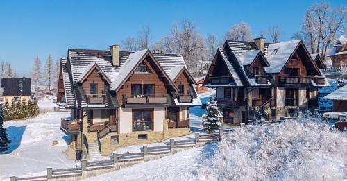 a large wooden house with snow on the roof at TatrApart in Zakopane
