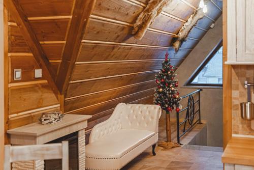 a living room with a christmas tree and a chair at TatrApart in Zakopane