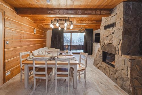 a dining room with a table and a stone fireplace at TatrApart in Zakopane