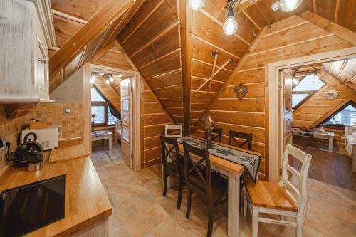 a kitchen and dining room of a log cabin with a table and chairs at TatrApart in Zakopane